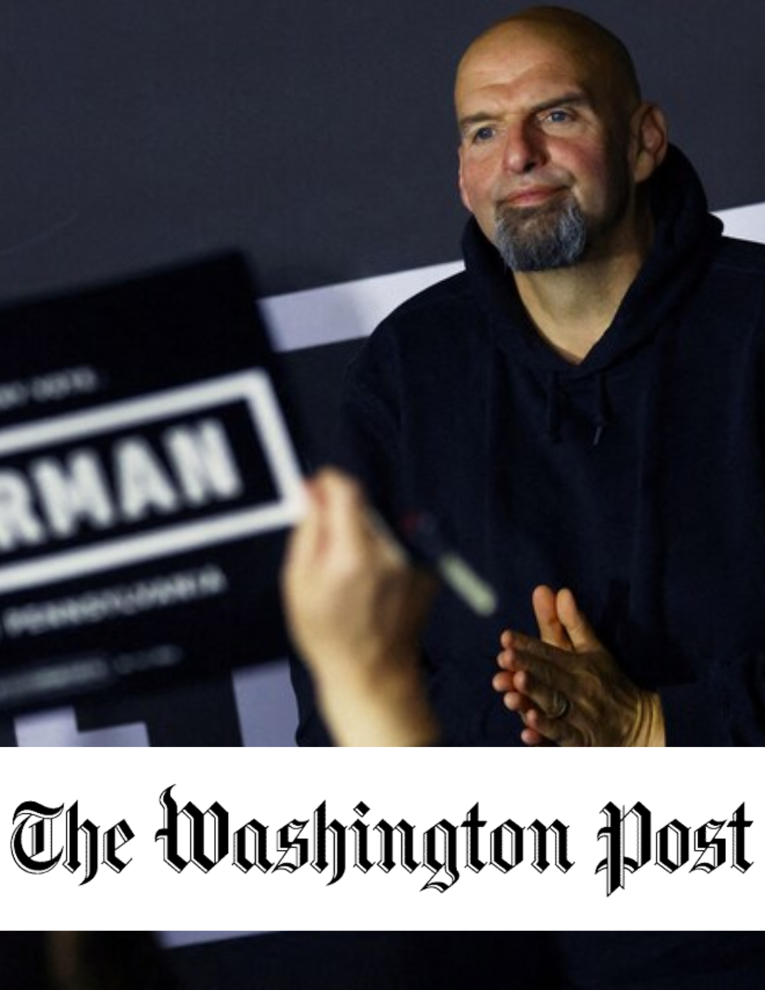 photo of Senator John Fetterman smiling with his hands clasped. Washington Post logo is on front of the photo. 